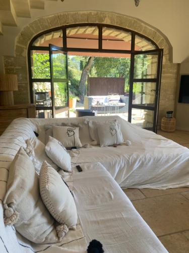 Cette chambre comprend un grand lit blanc et une grande fenêtre. dans l'établissement La Magnanerie d aubais, à Aubais