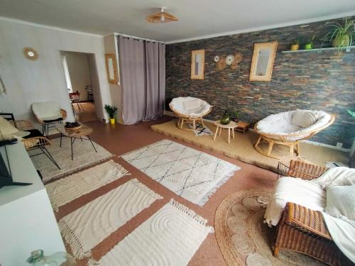 ein Wohnzimmer mit Sofas und einer Ziegelwand in der Unterkunft Au bonheur des voyageurs in Concarneau