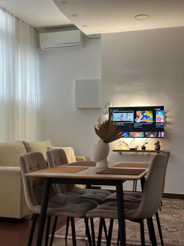 a dining room with a table and chairs and a couch at Duomo Apartment in Shkodër