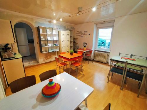 ein Zimmer mit Tisch und Stühlen und eine Küche in der Unterkunft Au bonheur des voyageurs in Concarneau