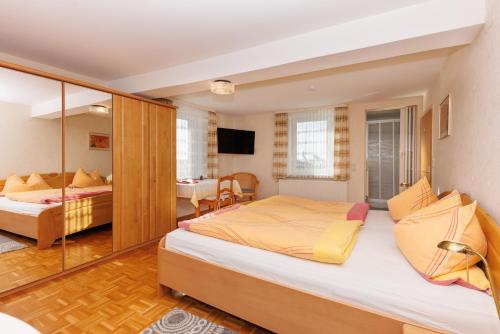 a bedroom with two beds and a living room at Bauernhof-Pension Schneider-Feige in Bad Berleburg