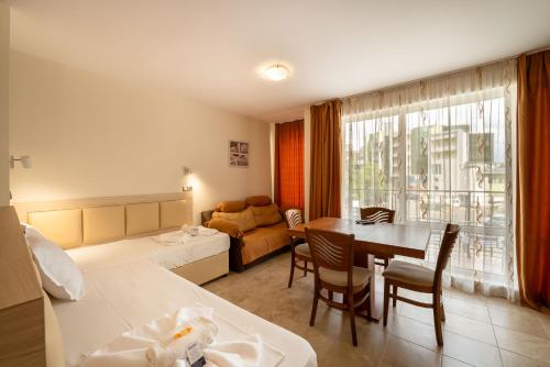 ein Hotelzimmer mit einem Bett und einem Esszimmer in der Unterkunft Perla Apartments in Nessebar