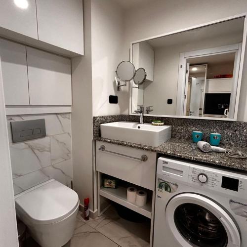 a bathroom with a sink and a washing machine at Apartment Twin Towers David in Batumi