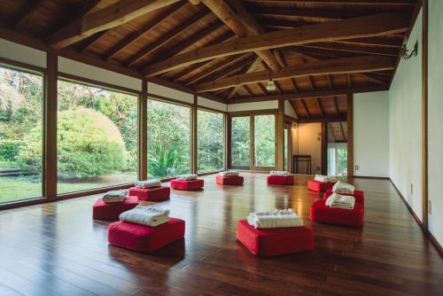 a room with red ottomans on a wooden floor at 伊豆大島の一棟貸切Retreat&StayBHOAG広いお庭でBBQ焚火okお子様歓迎8名定員 in Oshima