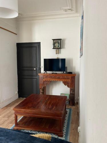 a living room with a table and a fireplace at L'Entre-Temps, Le Lys et L Iris in Saint-Aignan