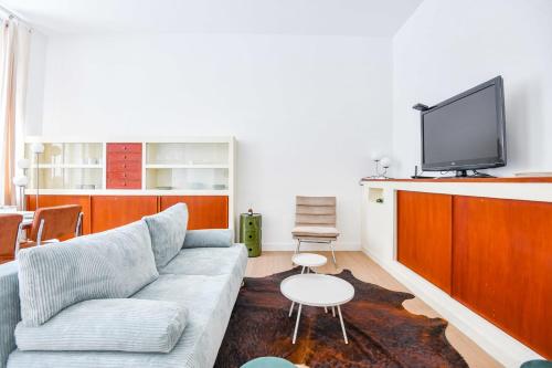 un salon avec un canapé et une télévision à écran plat dans l'établissement Appart 2 ch - proche métro Périer et Vélodrome, à Marseille