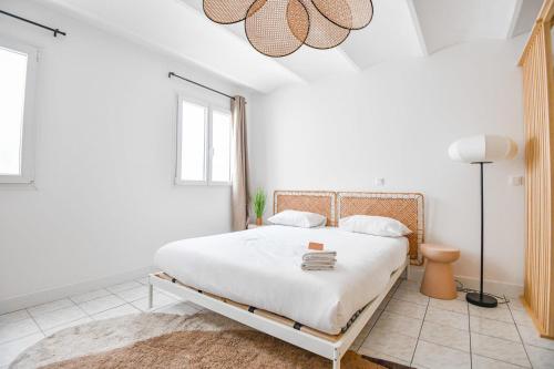 - une chambre blanche avec un lit blanc et une lampe dans l'établissement Appart 2 ch - proche métro Périer et Vélodrome, à Marseille