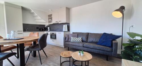 a living room with a couch and a table at 103C nieuwe vakantiewoning met sauna in Westkapelle