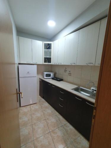 a kitchen with white cabinets and a sink and a refrigerator at Apartman Nikolaj - Lovely 3 room apartment in the center of Ohrid in Ohrid