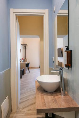 a bathroom with a bowl sink on a wooden counter at Rooftop Parthenopeo Contemporary Rooms in Naples