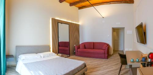 a bedroom with a bed and a red chair at Rooftop Parthenopeo Contemporary Rooms in Naples