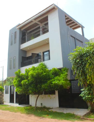 a building with a tree in front of it at MB Properties - Brufut Garden Apartments in Brufut