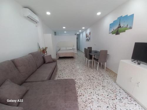 a living room with a couch and a dining room at Apartamento Paris in Alicante
