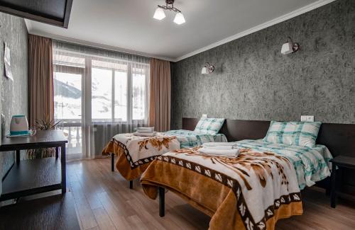 a bedroom with two beds and a couch at Roza Guesthouse in Stepantsminda