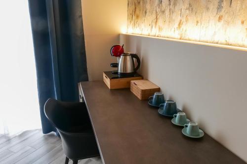 a table with cups and a kettle on it at Rooftop Parthenopeo Contemporary Rooms in Naples