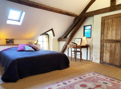 une chambre avec un lit et une table dans une pièce dans l'établissement Pierres de Loire, à Saint-Benoît-sur-Loire