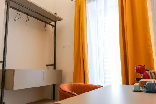 a room with a table and orange curtains at Rooftop Parthenopeo Contemporary Rooms in Naples