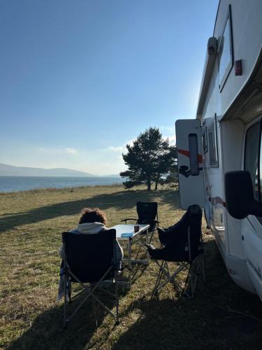 a person sitting in chairs in front of an rv at Camper Mobile Motorhome in Tbilisi City