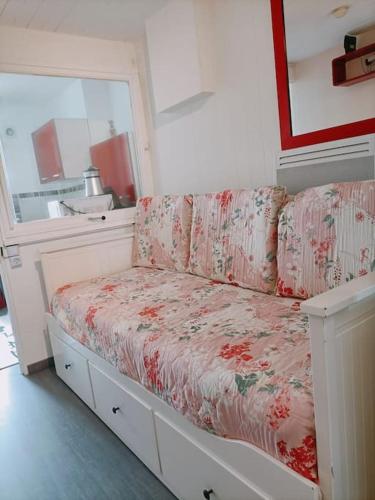 Cette chambre blanche dispose d'un canapé. dans l'établissement Studio fonctionnel au calme, à Franqueville-Saint-Pierre