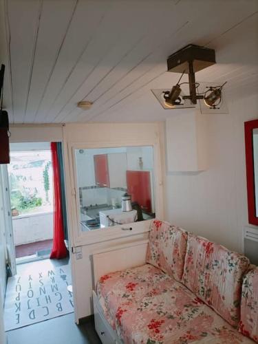 un salon avec un canapé et un miroir dans l'établissement Studio fonctionnel au calme, à Franqueville-Saint-Pierre