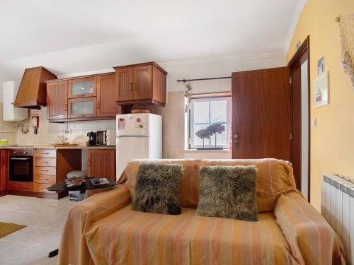 a kitchen with a couch in the middle of a room at Porto Dinheiro Beach II in Casal do Cigano