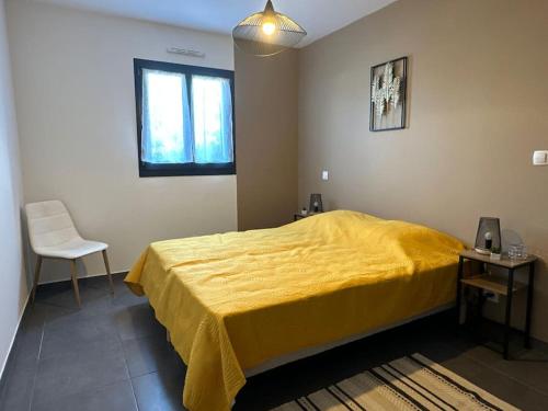 a bedroom with a yellow bed and a chair at 5 min des plages - Appt 2 chambres A Casa Bella in Lucciana