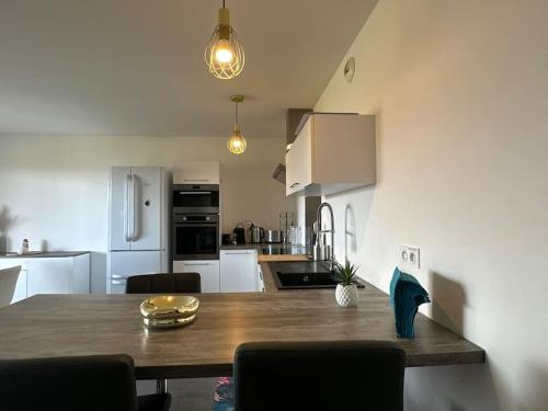 a kitchen with a wooden table and a kitchen with white appliances at 5 min des plages - Appt 2 chambres A Casa Bella in Lucciana