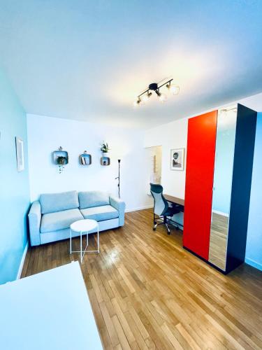 un salon avec un canapé et un bureau dans l'établissement Studio - Au calme quartier Pleyel RER Ligne 14, à Saint-Denis