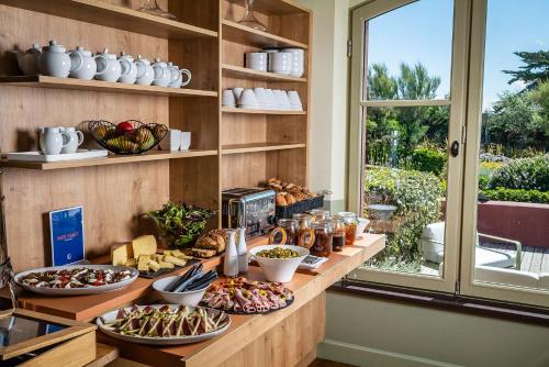 a buffet with plates of food on a counter at Le Grand Large, Belle-Ile-En-Mer in Bangor