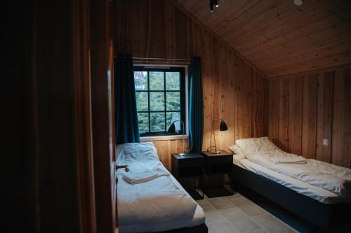 Un dormitorio con dos camas y una ventana. en Fanøy Island Lodge, en Fanoyna
