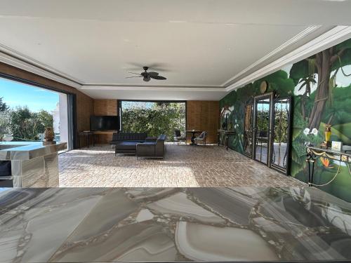 a living room with a couch and a ceiling fan at Maison d Hotes BLUE PALM Aix en PROVENCE in Aix-en-Provence