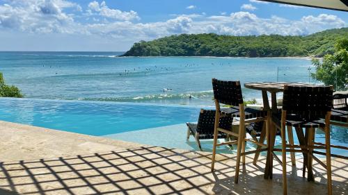 a table and chairs next to a view of the ocean at The Flamingo Experience in San Juan del Sur