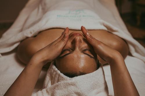 a woman laying in a bed with her hands on her face at RELAIS COLLE BUONO in Alvito