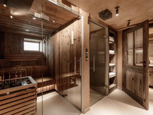 a bathroom with wooden walls and a glass walk in shower at Chalet Cecilia inklusive Summercard by MYALPS in Obergurgl