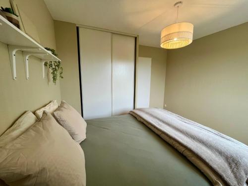 a bedroom with a bed with a blanket on it at Cayeux sur oiseaux in Cayeux-sur-Mer