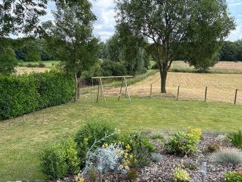 a park with a swing set in the grass at Le Gîte du Mont de la Hutte in Ploegsteert