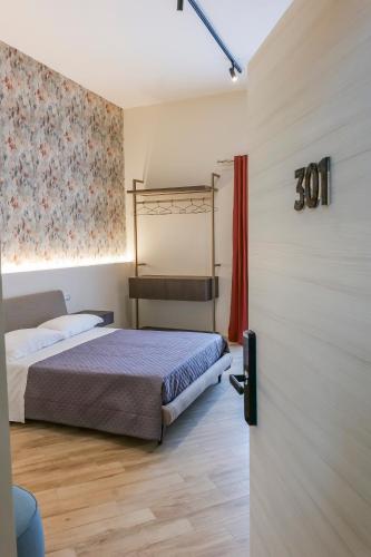 a bedroom with a bed and a sliding door at Rooftop Parthenopeo Contemporary Rooms in Naples