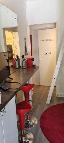 - une chambre avec une table, des chaises rouges et une porte dans l'établissement Paris 16 studio 1, à Paris