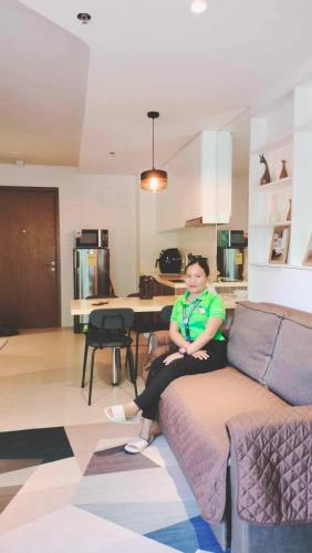a man sitting on a couch in a living room at Tower A one bedroom in Lapu Lapu City
