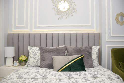 Cama con cabecero gris y almohadas en Le Monaco Suites - Azure North Pampanga, en San Agustin