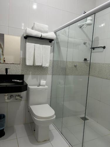 a bathroom with a toilet and a glass shower at Mais Hotel Express in São Luís