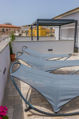 a row of chairs on the roof of a building at Rooftop Parthenopeo Contemporary Rooms in Naples