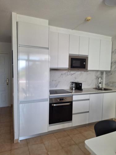 a white kitchen with a stove and a refrigerator at EL CARDENAL Casa Lise Playa del Cura in Playa del Cura