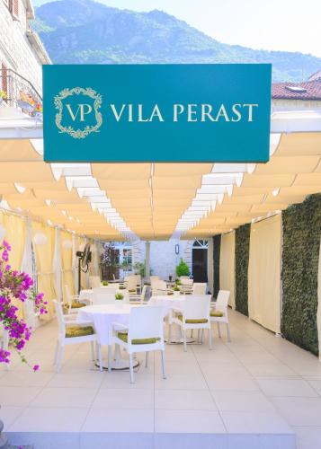 a restaurant with white tables and chairs and a sign that reads viva rental at Vila Perast Boutique Hotel in Perast