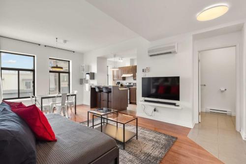 ein Wohnzimmer mit Couch und Fernseher und eine Küche in der Unterkunft M11 The LEGO Suite 2BRSofaBed in Prime Location in Montreal