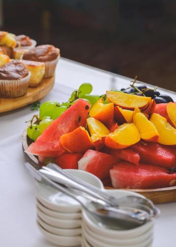 a bowl of fruit on a table with a spoon at Vila Perast Boutique Hotel in Perast