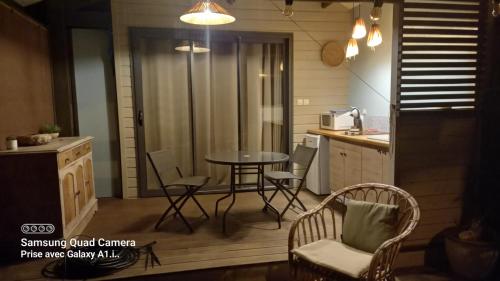 een keuken met een tafel en stoelen in een kamer bij Le latanier bleu in La Saline les Bains