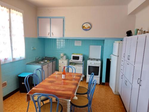 une cuisine avec une table en bois et des chaises. dans l'établissement 120m2 rdc 2km mer soleil catalan 2ch wifi 4pers ok chéques vacances animaux, à Latour-Bas-Elne