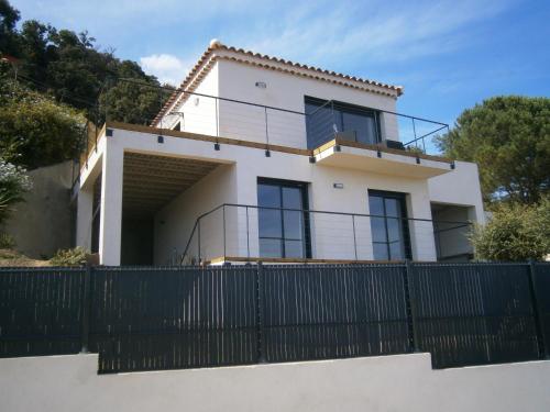 una casa blanca con una valla negra en Villa Azur, en Le Lavandou