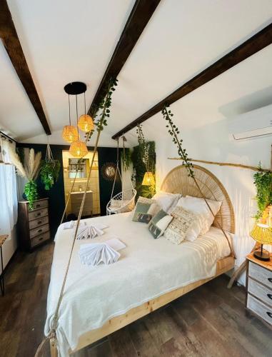 une chambre avec un grand lit avec des draps et des oreillers blancs dans l'établissement La Villa Tosca, à Callas